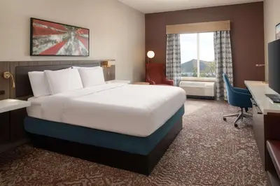 a hotel room with a bed and a desk at Hilton Garden Inn Fontana in Fontana