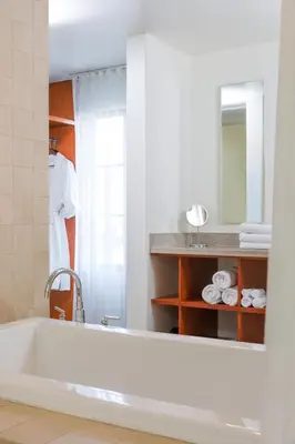 a bathroom with a tub and a person in a mirror at Hotel Casa 425 + Lounge, A Four Sisters Inn in Claremont