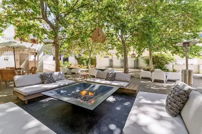 a patio with a fire pit and chairs and trees at Hotel Casa 425 + Lounge, A Four Sisters Inn in Claremont