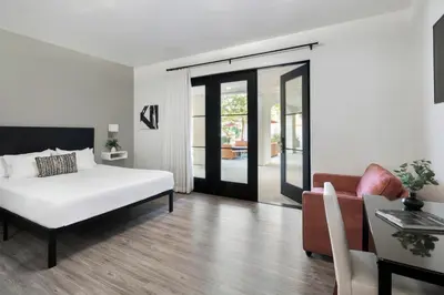 a bedroom with a bed and a living room with a couch at Hotel Casa 425 + Lounge, A Four Sisters Inn in Claremont