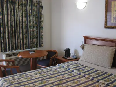 a hotel room with a bed and a table at Walls Motel Long Beach in Long Beach