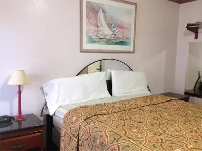 a hotel room with a bed and a picture on the wall at Walls Motel Long Beach in Long Beach