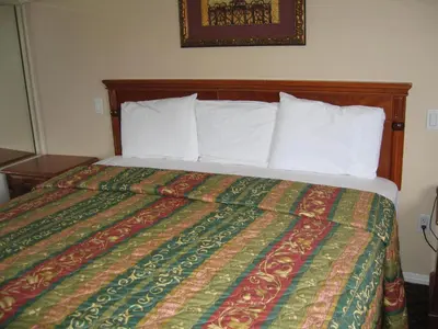 a bed in a hotel room with a colorful bedspread at Tower Motel Long Beach in Long Beach