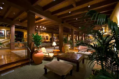 a lobby with chairs and a table and plants at The Mission Inn Hotel and Spa in Riverside