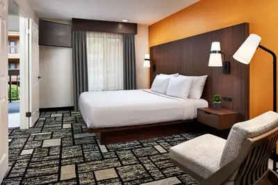 a hotel room with a bed and a chair at Best Western Plus Meridian Inn & Suites, Anaheim-Orange in Orange