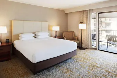 a hotel room with a large bed and a balcony at DoubleTree by Hilton Ontario Airport in Ontario