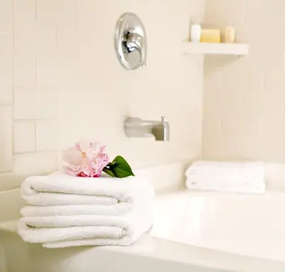 a white bathroom with towels on a sink at Ayres Suites Ontario at the Mills Mall - Rancho Cucamonga in Ontario