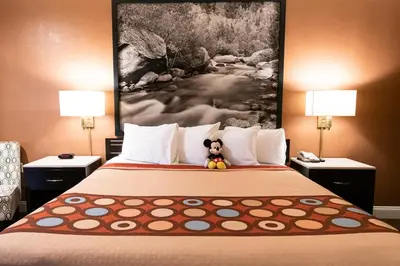 a hotel room with a bed with a teddy bear sitting on it at Super 8 by Wyndham Anaheim/Disneyland Drive in Anaheim