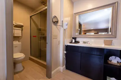 a bathroom with a toilet and a sink and a mirror at Super 8 by Wyndham Anaheim/Disneyland Drive in Anaheim