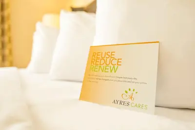a book on a bed with a house reduce review sign on it at Ayres Hotel Anaheim in Anaheim