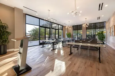 a dining room with tables and chairs and large windows at Home2 Suites By Hilton Anaheim Resort in Anaheim