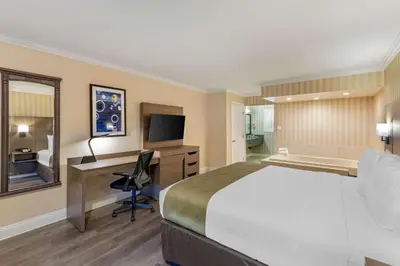 a hotel room with a bed and a desk at Quality Inn & Suites Anaheim Maingate in Anaheim