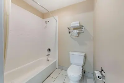 a bathroom with a toilet and a tub and a sink at Quality Inn & Suites Anaheim Maingate in Anaheim