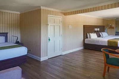 a hotel room with two beds and a table at Quality Inn & Suites Anaheim Maingate in Anaheim
