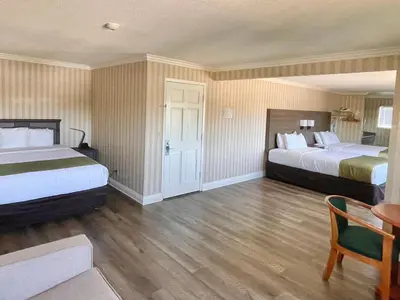 a hotel room with two beds and a table at Quality Inn & Suites Anaheim Maingate in Anaheim