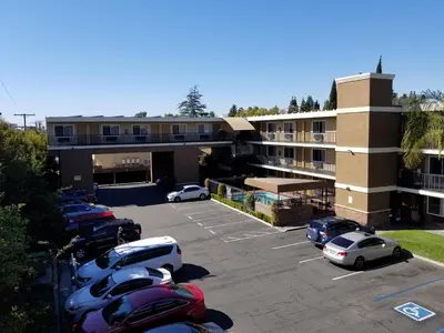 a parking lot with cars parked in front of a building at Quality Inn & Suites Anaheim Maingate in Anaheim