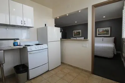 a kitchen with a stove and a refrigerator and a bed at Dunes Inn - Wilshire in Los Angeles