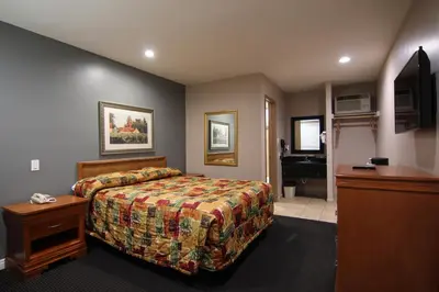 a hotel room with a bed and a bathroom at Dunes Inn - Sunset in Los Angeles