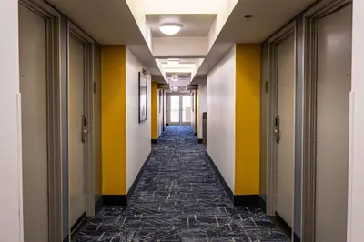 an empty hallway in an office building with yellow and white walls at Comfort Inn & Suites Near Universal - N Hollywood - Burbank in Los Angeles