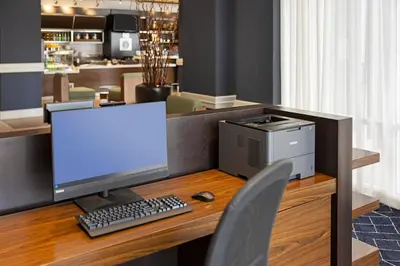 a desk with a computer monitor and a keyboard and mouse at Courtyard by Marriott Baldwin Park in Baldwin Park