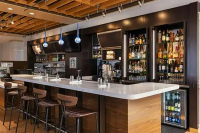 a bar in a restaurant with bar stools at Courtyard by Marriott Baldwin Park in Baldwin Park