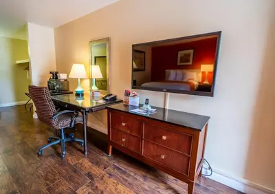 a hotel room with a desk and a bed at Howard Johnson by Wyndham Buena Park in Buena Park