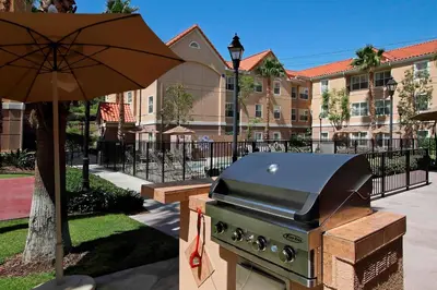 a grill with an umbrella next to a building at Residence Inn Anaheim Hills Yorba Linda in Anaheim