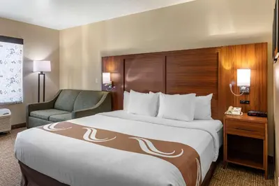 a hotel room with a large bed and a chair at Quality Inn Placentia Anaheim Fullerton in Placentia