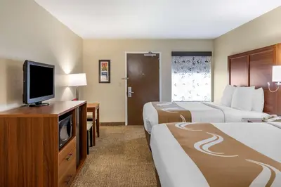 a hotel room with two beds and a flat screen tv at Quality Inn Placentia Anaheim Fullerton in Placentia
