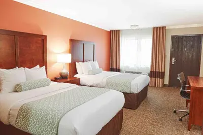 a hotel room with two beds and a desk at The Hills Inn Eagle Rock - Near Old Town Pasadena in Los Angeles