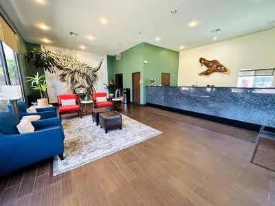 a lobby with a waiting area with chairs and a bear mural at The Hills Inn Eagle Rock - Near Old Town Pasadena in Los Angeles