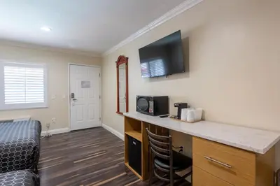 a room with a desk with a tv on the wall at Hollywood City Inn in Los Angeles