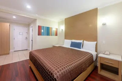 a hotel room with a bed and a hallway at Hollywood City Inn in Los Angeles