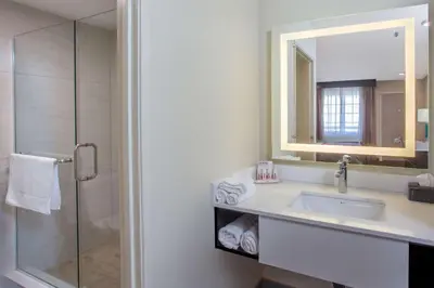 a bathroom with a sink and a mirror and a shower at Ramada by Wyndham Culver City in Los Angeles
