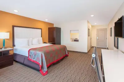 a hotel room with a bed and a television at Ramada by Wyndham Culver City in Los Angeles