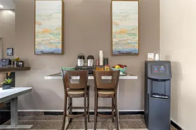 a kitchen with a bar with two chairs and a trash at Best Western Redondo Beach Galleria Hotel - Beach City LA in Redondo Beach