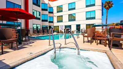 a hot tub at a hotel with chairs and a building at Best Western Plus Suites Hotel - LAX Airport LA Stadium in Inglewood
