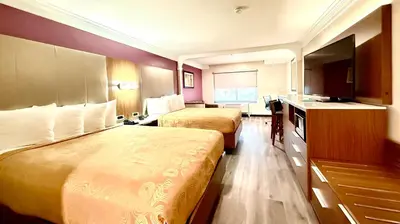a hotel room with two beds and a television at Best Western Plus Suites Hotel - LAX Airport LA Stadium in Inglewood