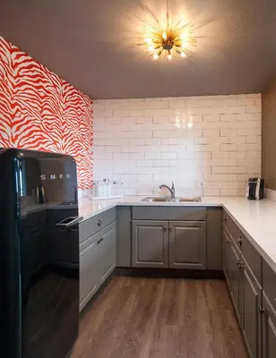 a kitchen with a sink and a black refrigerator at Hotel Hermosa in Hermosa Beach