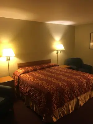 a hotel room with a bed and two lamps at Century Inn at LAX in Inglewood