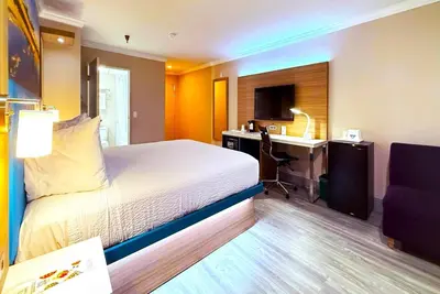 a bedroom with a bed and a desk with a computer at Days Inn by Wyndham Los Angeles LAX South Bay Beach City LA in Lawndale