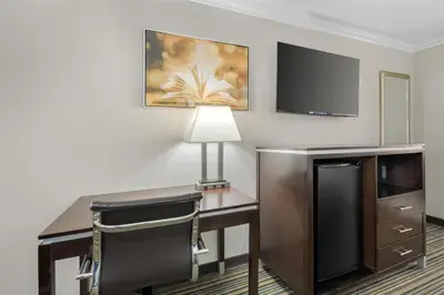 a hotel room with a desk and a flat screen tv at Best Western Courtesy Hotel - Anaheim Resort Amusement Park in Anaheim