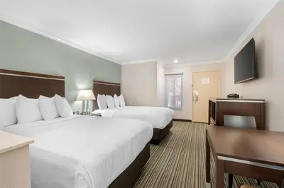 a hotel room with two beds and a flat screen tv at Best Western Courtesy Hotel - Anaheim Resort Amusement Park in Anaheim