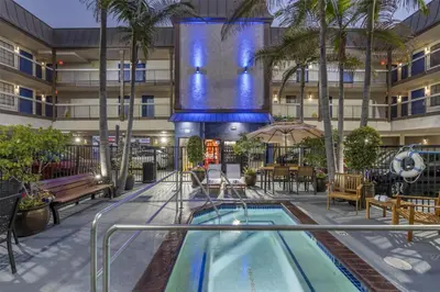 a pool in a hotel with palm trees and a building at Best Western Airport Plaza Hotel – LAX Airport LA Stadium in Los Angeles