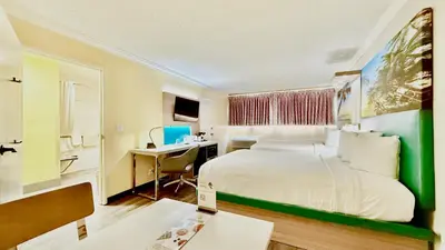 a hotel room with a bed and a desk with a computer at Days Inn by Wyndham Los Angeles LAX Airport Stadium Area in Los Angeles