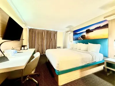 a hotel room with a bed and a desk at Days Inn by Wyndham Los Angeles LAX Airport Stadium Area in Los Angeles