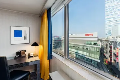 a room with a desk and a large window at E Central Hotel Downtown Los Angeles in Los Angeles