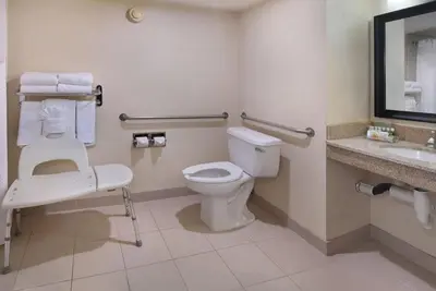 a bathroom with a toilet and a sink at Holiday Inn Hotel & Suites Anaheim by IHG in Anaheim