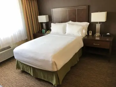 a large bed in a hotel room with two lamps at Holiday Inn Hotel & Suites Anaheim by IHG in Anaheim