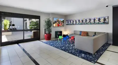 a living room with a couch and a table and chairs at Holiday Inn Hotel & Suites Anaheim by IHG in Anaheim